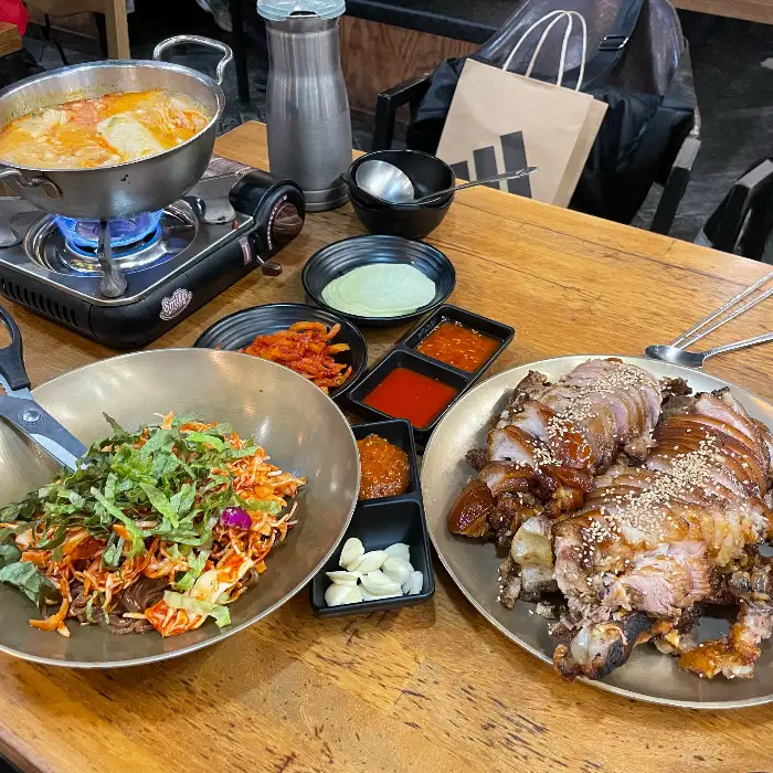 푸짐한 한상 차림, 족발과 막국수, 찌개 등이 보임