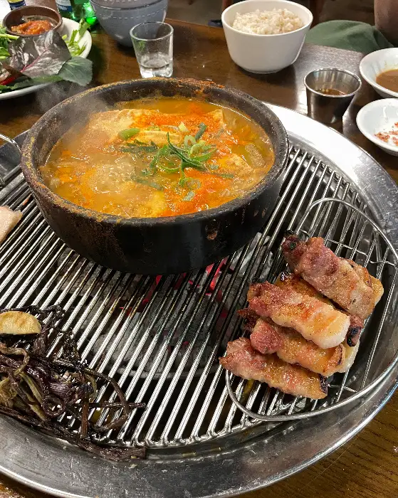 숯불 위에서 맛있게 익어가고 있는 오겹살 덩어리