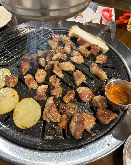 동그란 불판 위에서 노릇하게 구워지고 있는 얇게 썬 고기 조각들