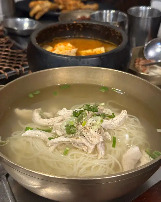 김이 모락모락 나는 닭 육수 국수 요리