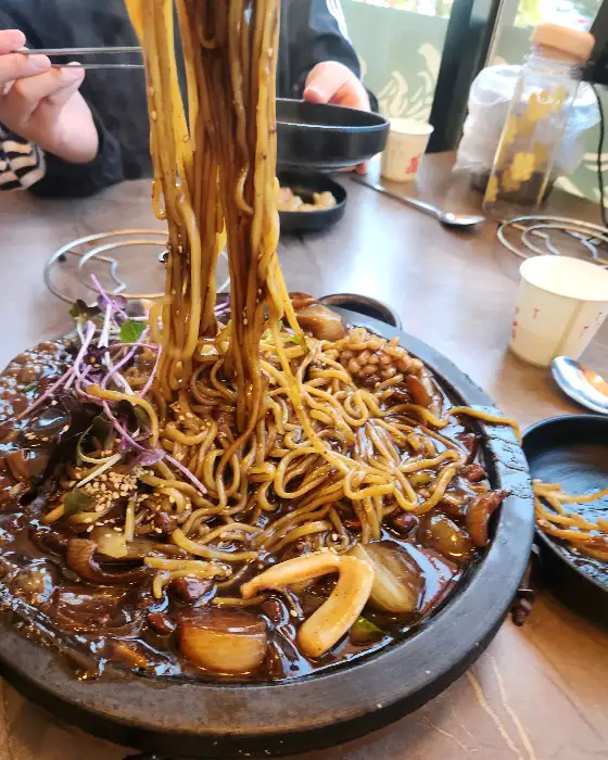 따뜻하게 김이 나는 짬뽕 면발을 들어 올리는 모습