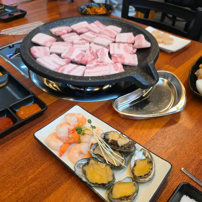 신선한 전복, 새우, 관자와 함께 구워지는 고기