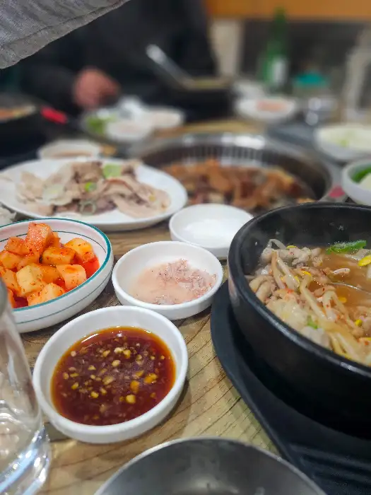 테이블에 놓인 여러 음식들, 국밥과 곱창구이
