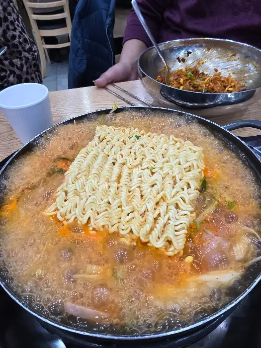부대찌개 국물에 밥을 비벼 먹는 모습