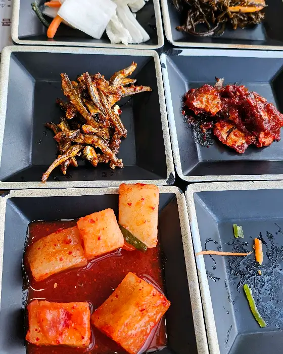 작은 접시에 담긴 멸치볶음, 고춧잎장아찌, 물김치, 겉절이 김치 등의 모습