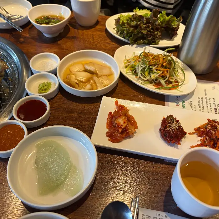 테이블에 차려진 다양한 밑반찬과 쌈 채소