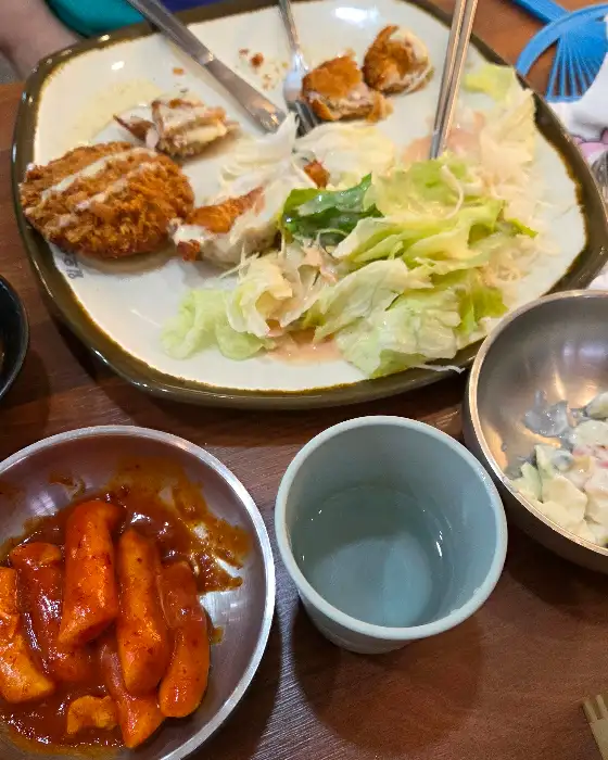 테이블 위에 놓인 떡볶이와 컵