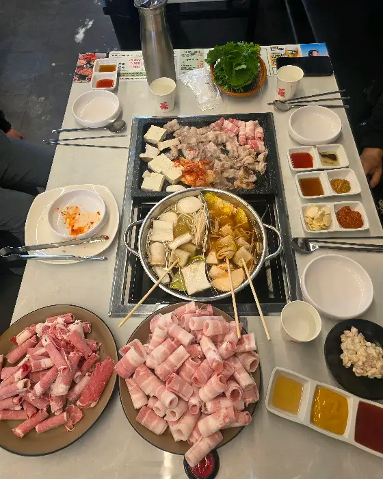 다양한 고기와 샤브샤브 재료가 차려진 테이블