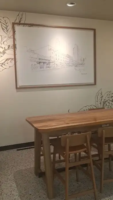 벽에 걸린 스케치 그림과 나무 테이블