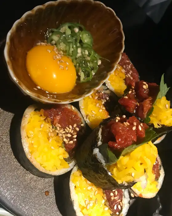 육회김밥과 계란 노른자, 곁들임 채소의 모습