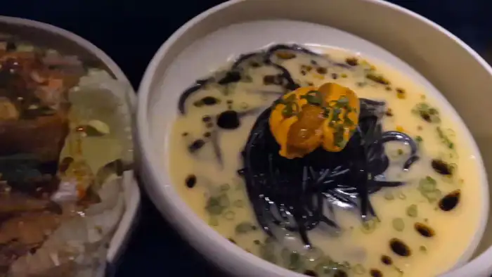 검은색 면과 성게알이 올라간 파스타 요리