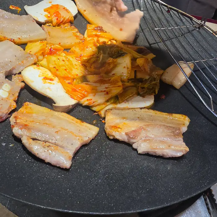 잘 구워진 삼겹살 조각과 볶아진 김치