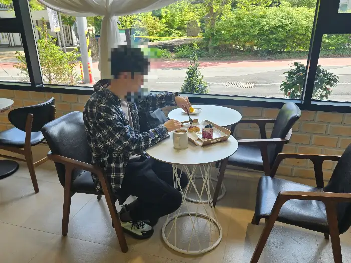 카페 테이블에서 빵과 음료를 즐기는 사람