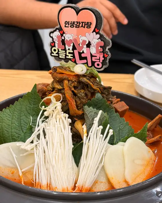 감자탕 위에 장식된 버섯과 채소, 그리고 하트 모양 장식