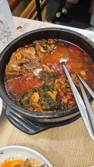 집게와 젓가락으로 감자탕을 집는 모습