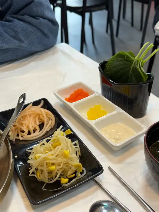 셀프바에 놓인 깻잎, 콩나물, 타르타르 소스 등 곁들임 메뉴들.