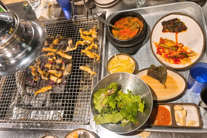 테이블에 차려진 푸짐한 한상차림 (장어구이, 장어탕, 반찬 등)