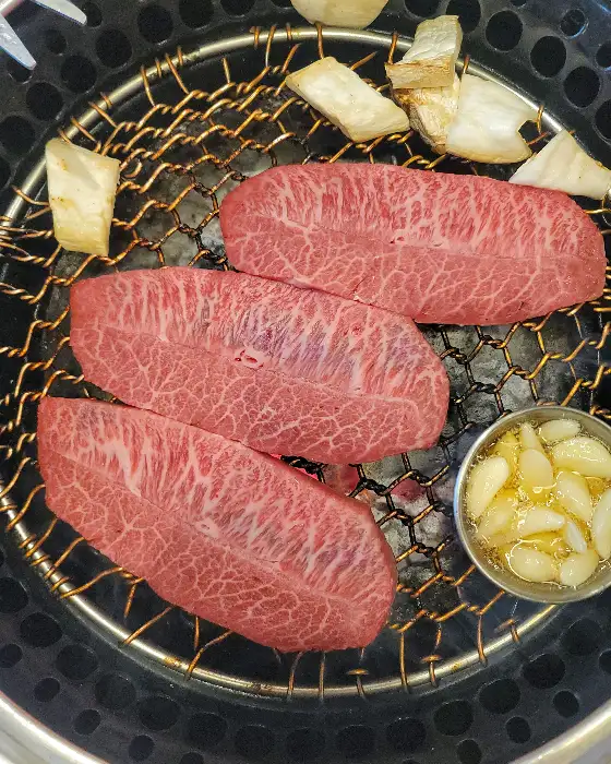 다양한 부위의 소고기가 숯불 위에서 구워지는 모습