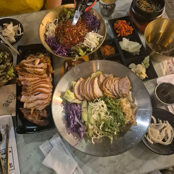 테이블 가득 차려진 족발, 막국수, 김치찜 등 다양한 음식들