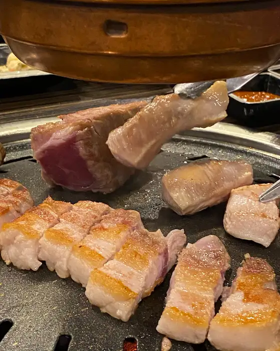 불판 위에서 구워지고 있는 삼겹살 덩어리들