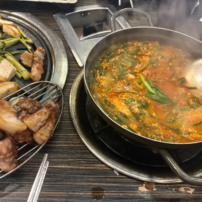 김치찌개와 함께 놓인 구워진 고기