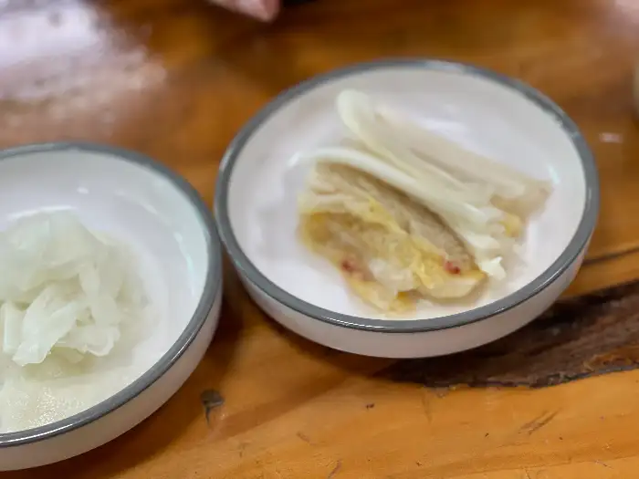 밑반찬으로 나온 백김치와 다른 나물 반찬