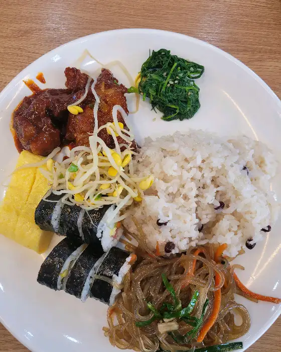 김밥, 계란말이, 튀김, 잡채, 밥 등이 담긴 접시