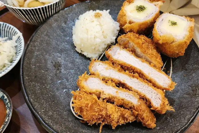 치즈가 올라간 돈까스와 밥, 샐러드로 구성된 메뉴