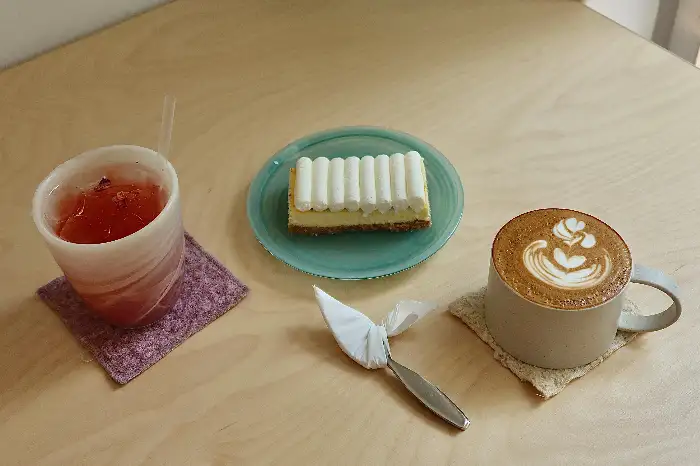 음료와 케이크, 커트러리가 놓여진 테이블 상세 샷