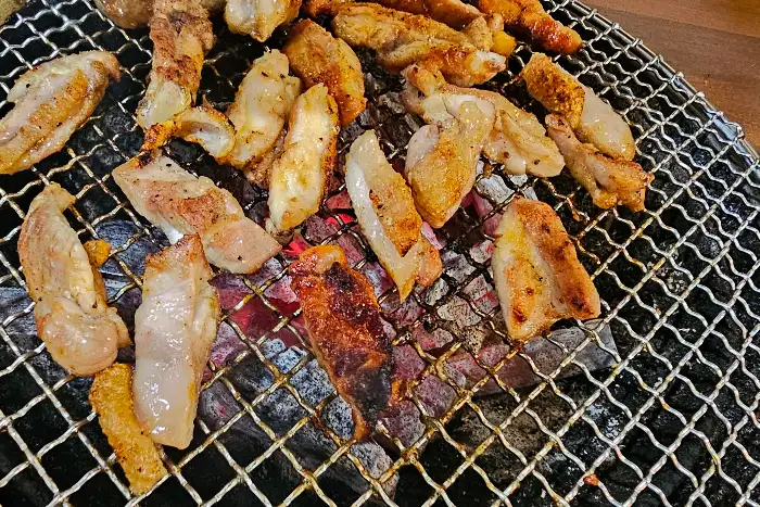 숯불 위에서 구워지고 있는 다양한 부위의 닭고기