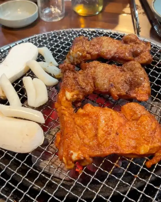 숯불 위에서 익고 있는 닭갈비와 떡, 버섯
