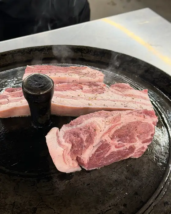 솥뚜껑 위에서 맛있게 익어가는 삼겹살