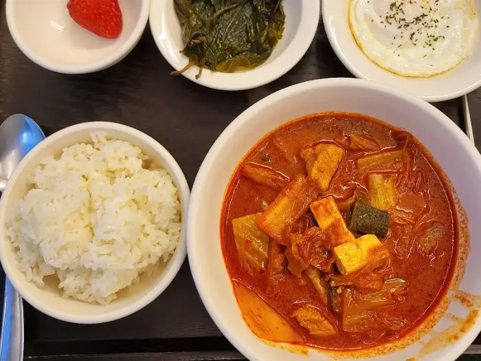 김치찌개, 밥, 계란후라이, 반찬이 함께 나온 상차림