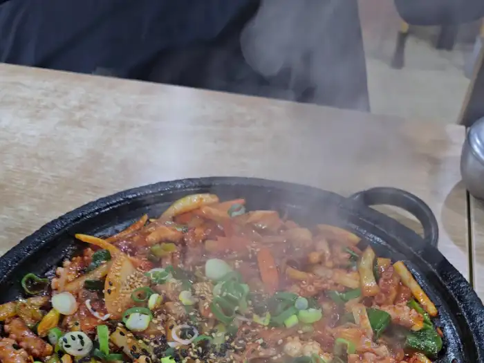 철판 위에서 끓고 있는 오징어제육볶음