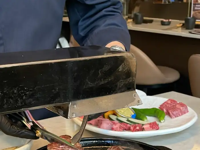 셰프가 집게와 가위로 고기를 능숙하게 다루고 있는 모습