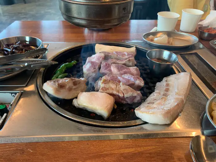 노릇하게 구워진 흑돼지 한 점과 멜젓