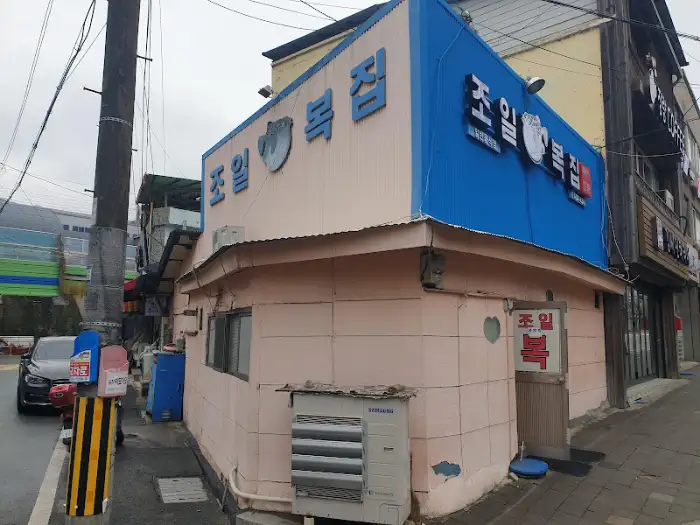 핑크색 건물에 파란색 간판이 돋보이는 식당 외관