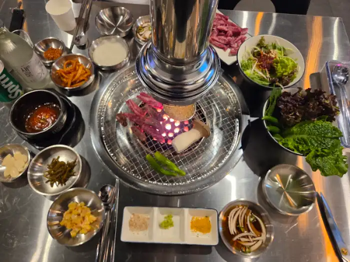 테이블 전체 상차림을 보여주는 모습. 넉넉한 양의 고기와 밑반찬이 시선을 사로잡는다.