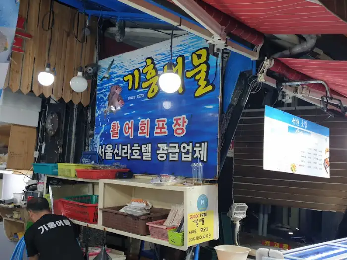 횟집 입구의 간판. '기흥어물'이라는 상호와 함께 '활어회 포장' 등의 문구가 쓰여 있다.