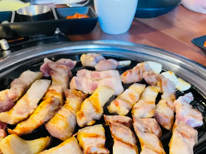 숯불 위에서 맛있게 구워지고 있는 두툼한 삼겹살