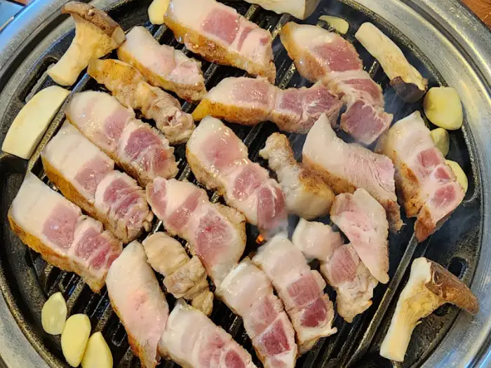 숯불 위에서 익어가는 주먹구이와 버섯, 마늘