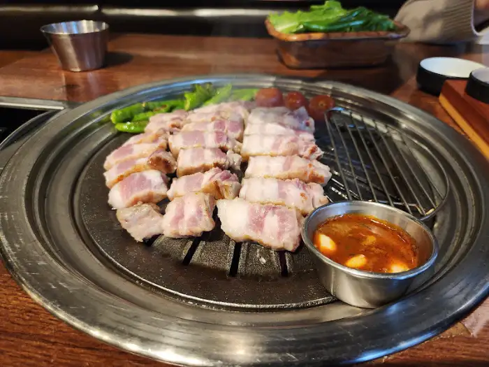 김이 모락모락 나는 돼지고기 구이와 곁들임 소스