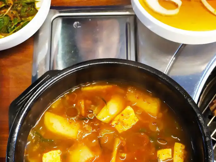 김치찌개로 보이는 뜨거운 뚝배기.