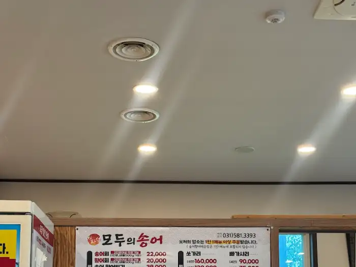 실내 천장의 조명과 메뉴판 일부가 보이는 모습
