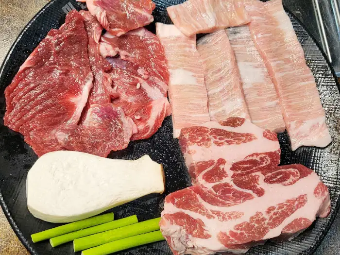 신선하고 다양한 종류의 고기가 접시에 보기 좋게 담겨 있다.