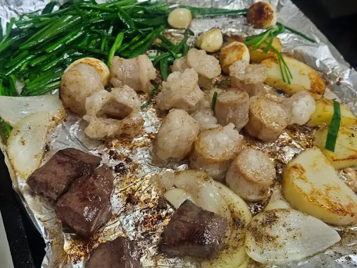 초벌 된 곱창과 대창, 떡, 채소가 불판에 놓여있는 모습