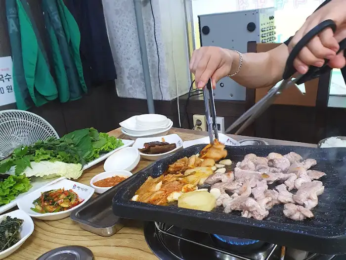 오리고기와 채소를 불판에 굽는 모습