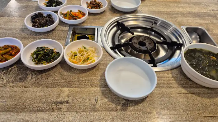 테이블 위에 여러 반찬과 함께 놓인 동태탕 그릇