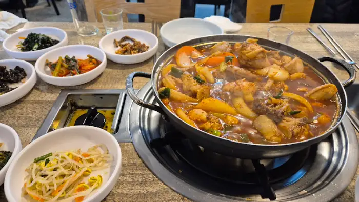 닭볶음탕 냄비와 여러 반찬들이 놓인 테이블의 전경