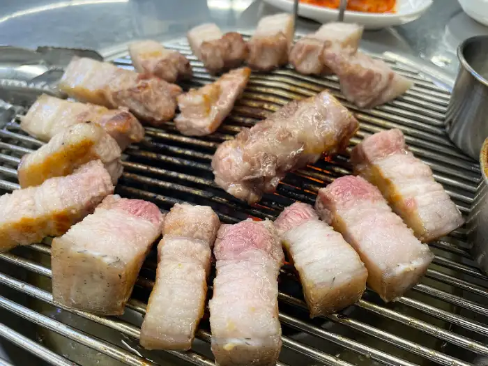 잘 익은 돼지고기 조각들이 불판 위에 놓여 있는 모습